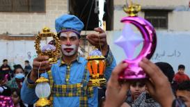 مهرجون يحتفلون مع الأطفال ويوزعون الهدايا عليهم، في اليوم الأول لشهر رمضان المبارك في خانيونس جنوب قطاع غزة.