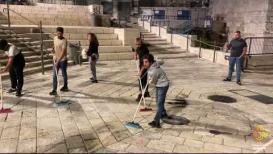 فلسطينيون ينظفون باب العامود بعد مسيرة الأعلام من قبل المستوطنين المتطرفين في القدس