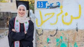 منى الكرد تقف أمام منزلها في حي الشيخ جراح بعد تخرجها من جامعة بيرزيت