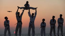 فريق "فنون" للتايكواندو يمارسون التمارين والحركات الاستعراضية على شاطئ البحر في مدينة خانيونس