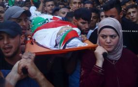 والدة الشهيد وسيم أبو خليفة تحمله على كتفها في جنازته